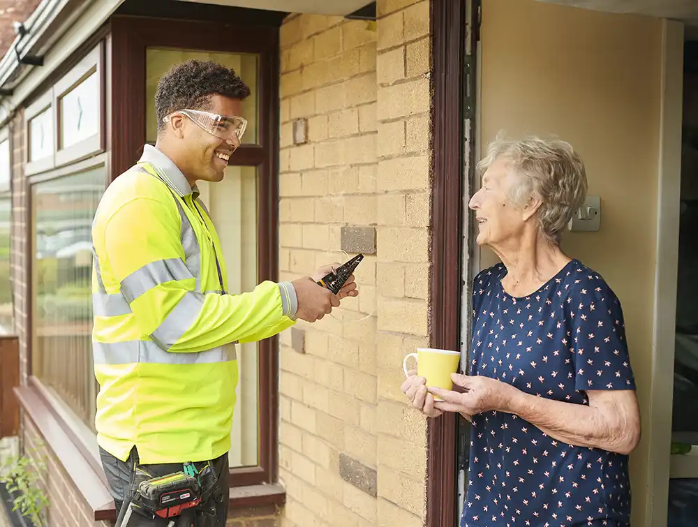 A man assisting the elderly with home wiring.